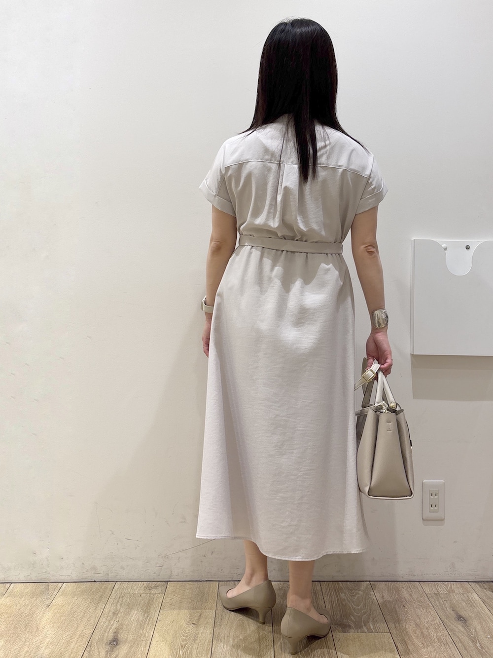 ベージュ系のワンピース、ベージュ系のトートバッグ、ベージュ系のパンプスを着用したレディースの夏コーディネートの4枚目の写真