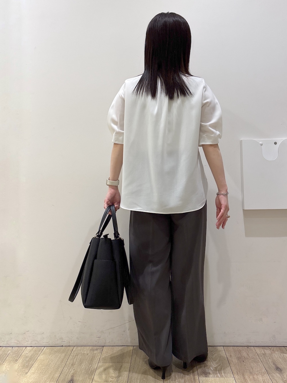 ブラック系のトートバッグ、ブラック系のパンプス、ホワイト系のシャツ/ブラウスを着用したレディースの春コーディネートの3枚目の写真