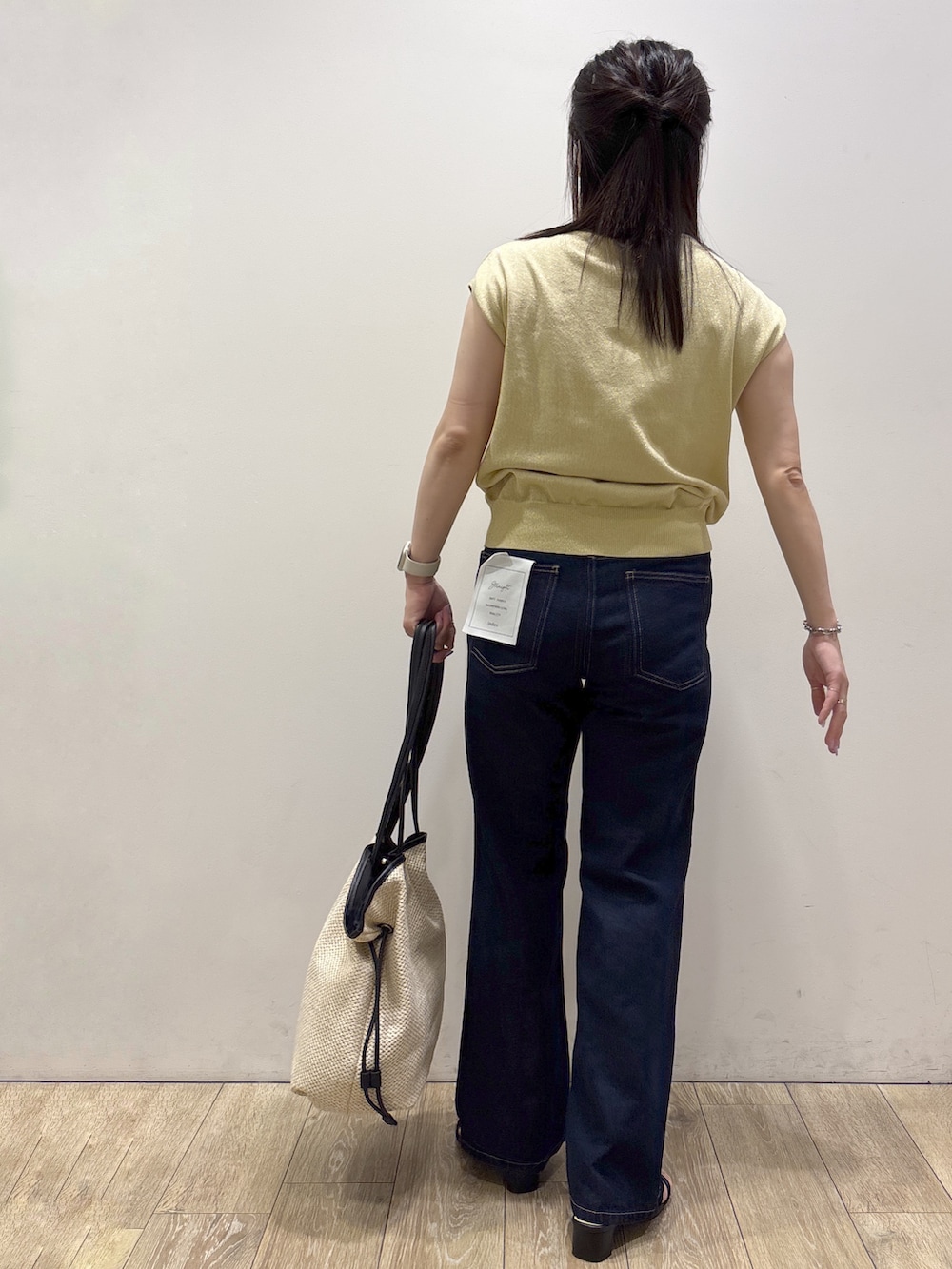 イエロー系のニット/セーター、ブルー系のその他パンツ、ホワイト系のトートバッグを着用したレディースの夏コーディネートの3枚目の写真