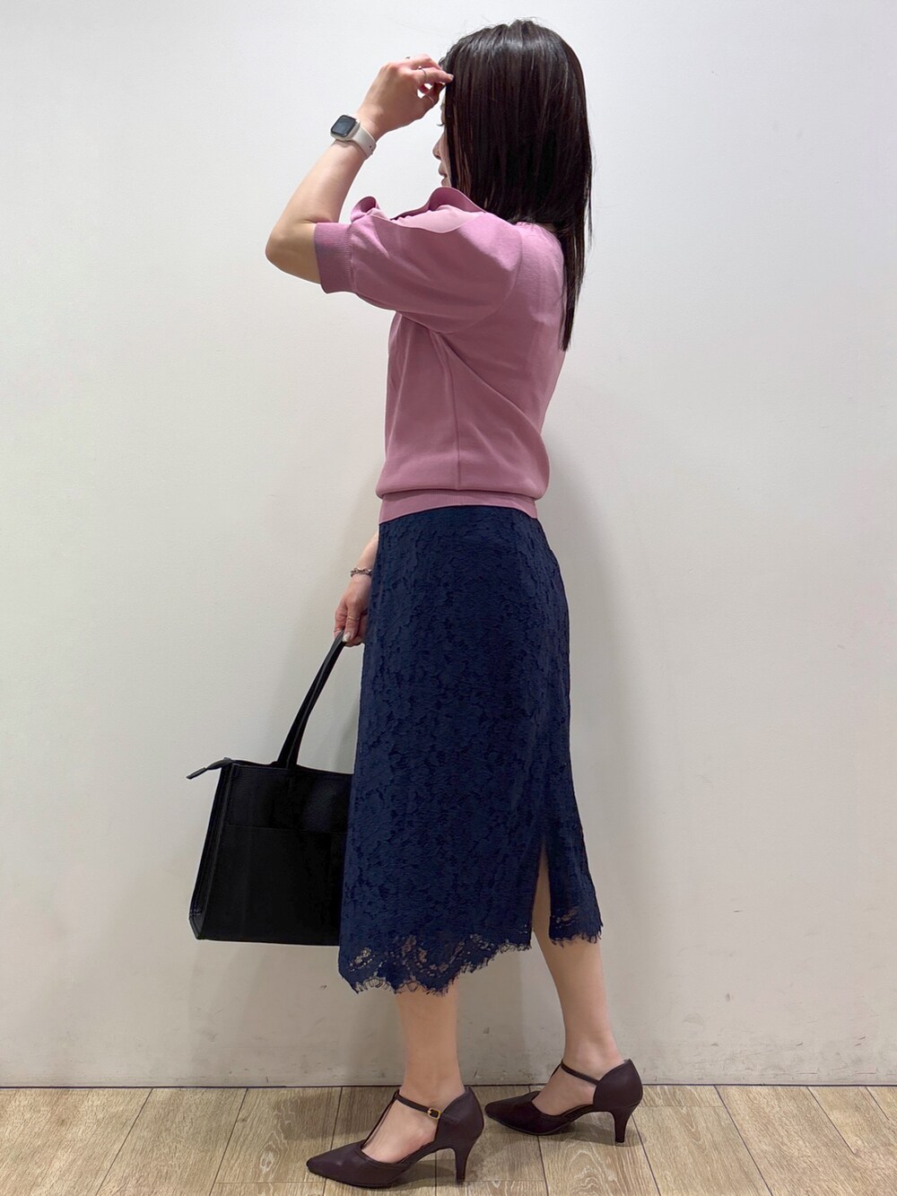 ピンク系のニット/セーター、ブラック系のトートバッグ、レッド系のパンプスを着用したレディースの夏コーディネートの5枚目の写真