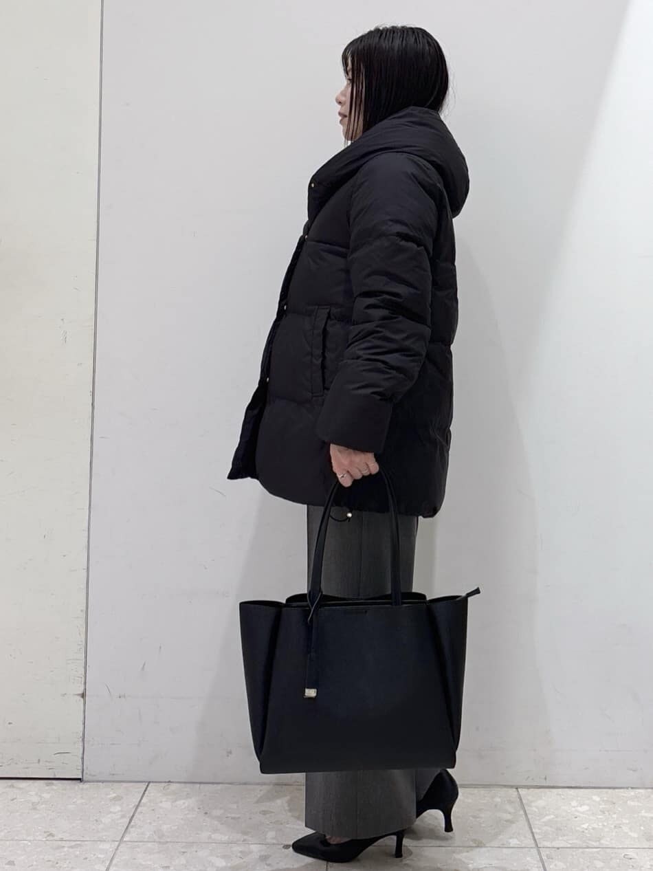 ブラック系のダウンジャケット/コート、ブルー系のニット/セーター、グレー系のその他パンツを着用したレディースの冬コーディネートの2枚目の写真
