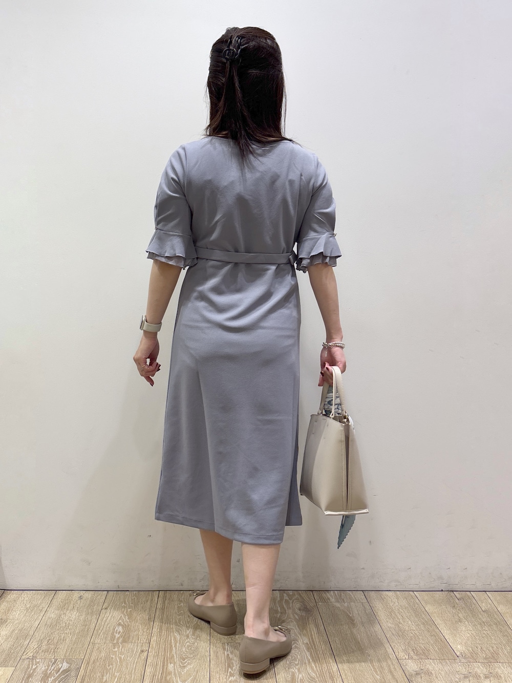 ブルー系のワンピース、ベージュ系のトートバッグ、ベージュ系のパンプスを着用したレディースの夏コーディネートの3枚目の写真