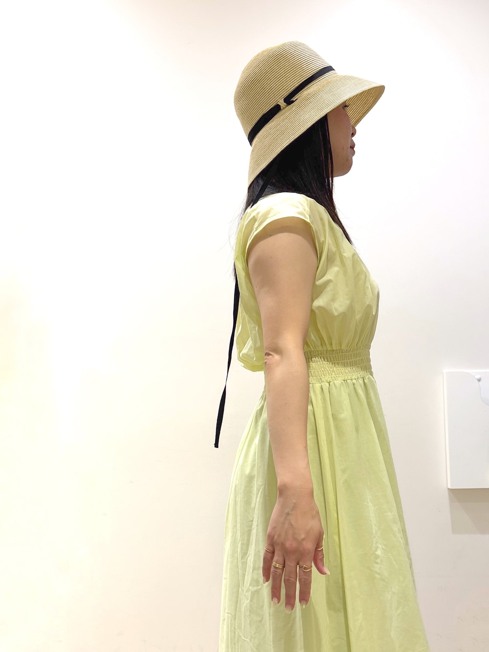 イエロー系のワンピース、ベージュ系のトートバッグ、ブラック系のサンダルを着用したレディースの夏コーディネートの8枚目の写真