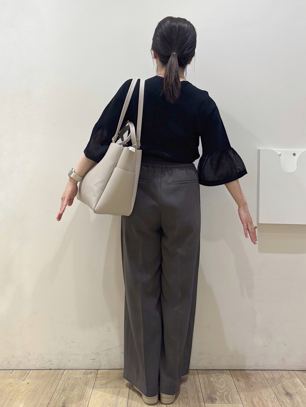 ベージュ系のパンプス、グレー系のカーディガン/ボレロ、ベージュ系のトートバッグを着用したレディースの春コーディネートの3枚目の写真
