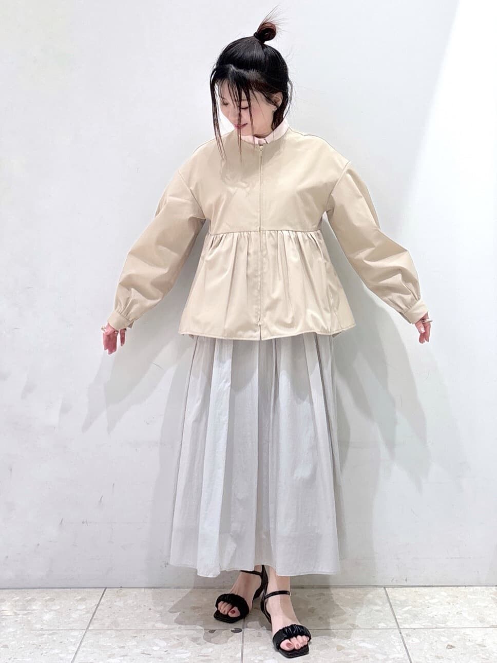 ベージュ系のノーカラージャケット、ピンク系のシャツ/ブラウス、グレー系のスカートを着用したレディースの春コーディネートの9枚目の写真