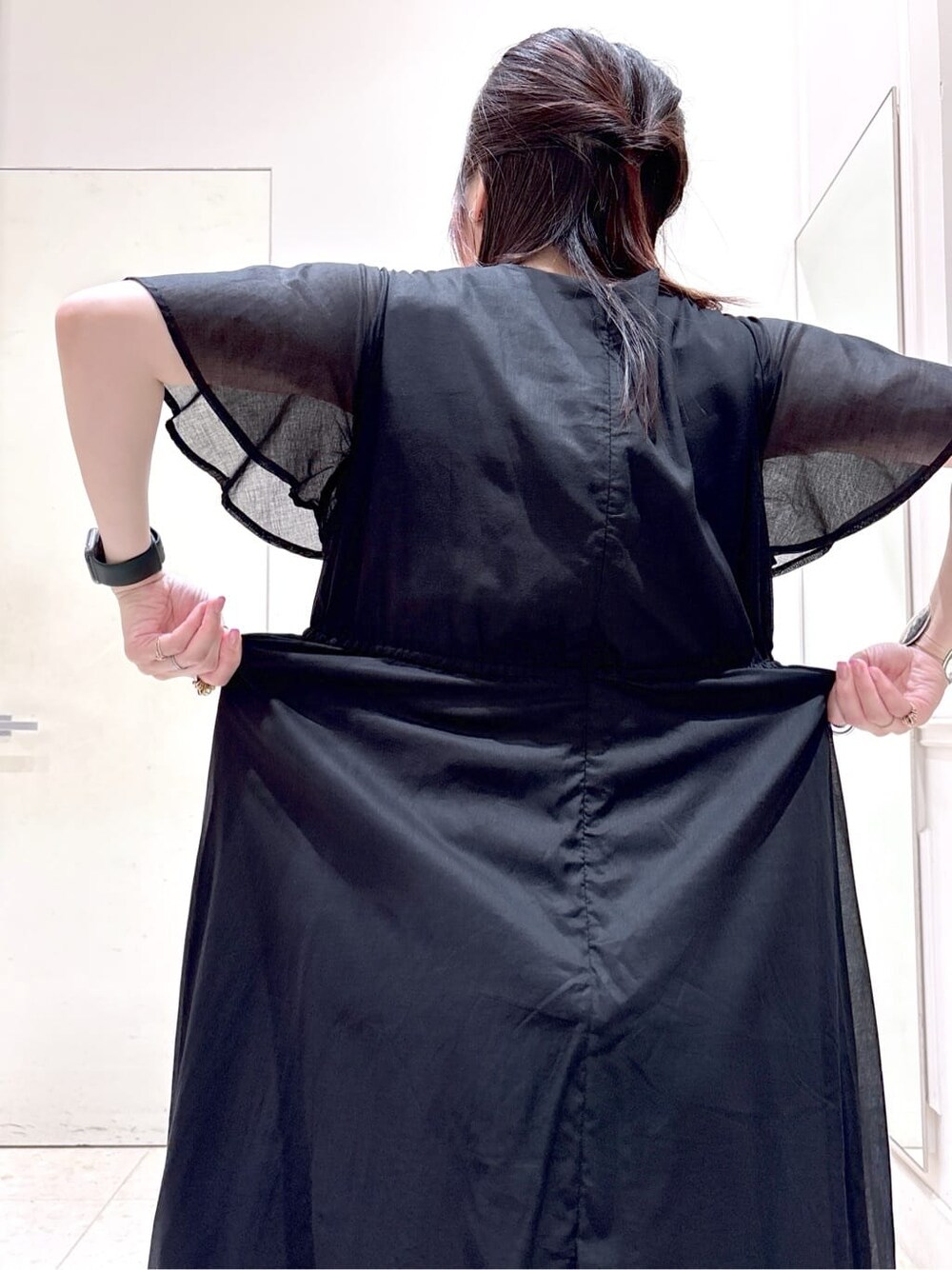 ブラック系のワンピース、ブラック系のトートバッグ、ブラック系のパンプスを着用したレディースの夏コーディネートの7枚目の写真