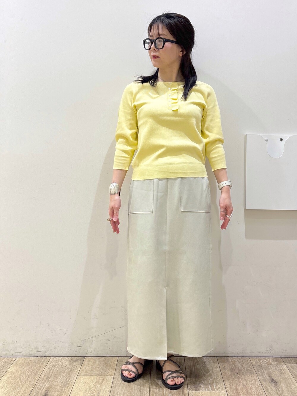 ベージュ系のスカート、シルバー系のサンダル、ホワイト系のトートバッグを着用したレディースの春コーディネートの10枚目の写真