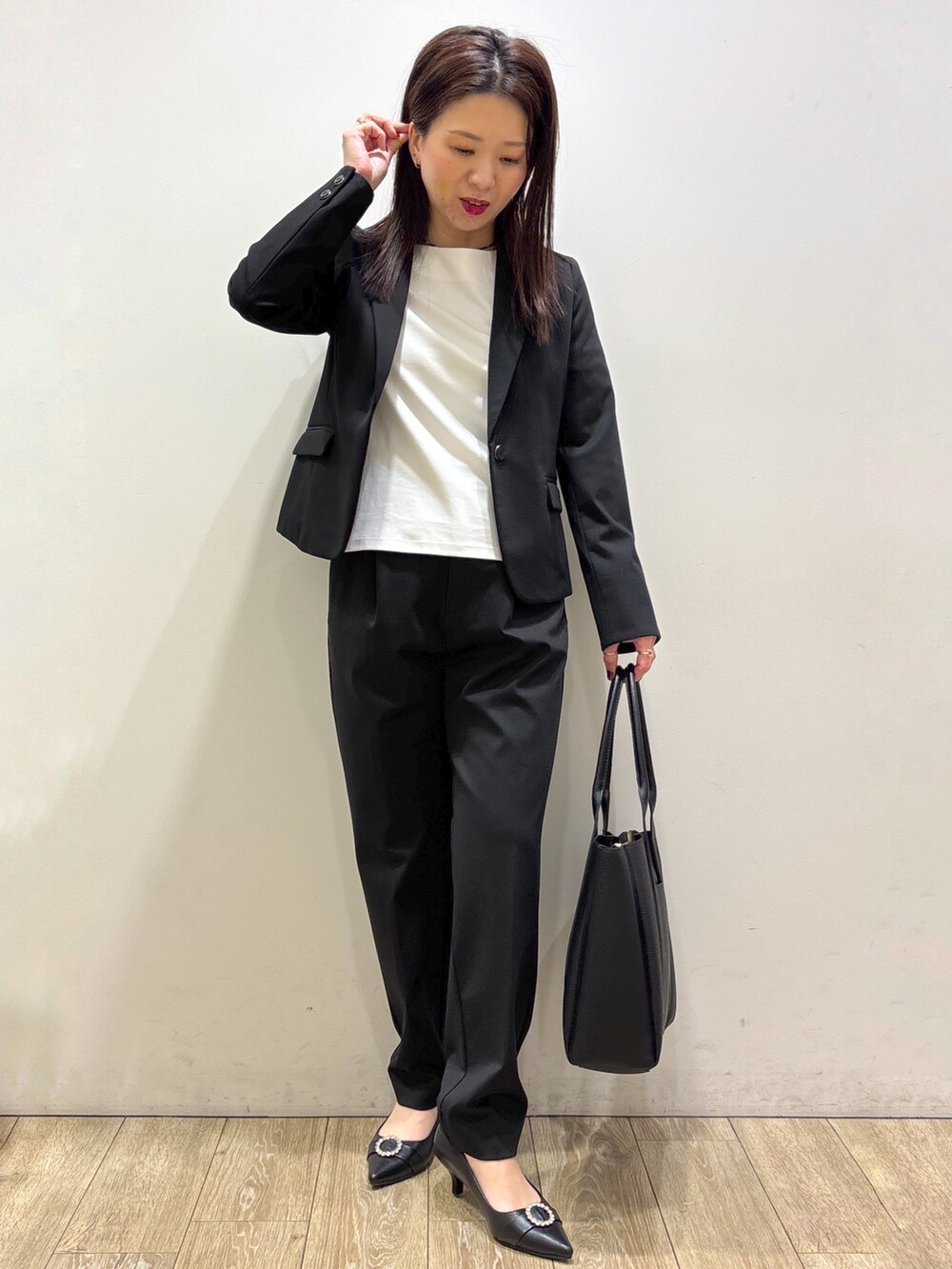 ブラック系のテーラードジャケット、ホワイト系のTシャツ/カットソー、ブラック系のその他パンツを着用したレディースの秋コーディネートの6枚目の写真