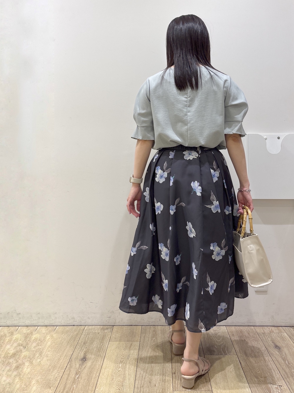 グレー系のスカート、ホワイト系のトートバッグ、ベージュ系のサンダルを着用したレディースの夏コーディネートの3枚目の写真