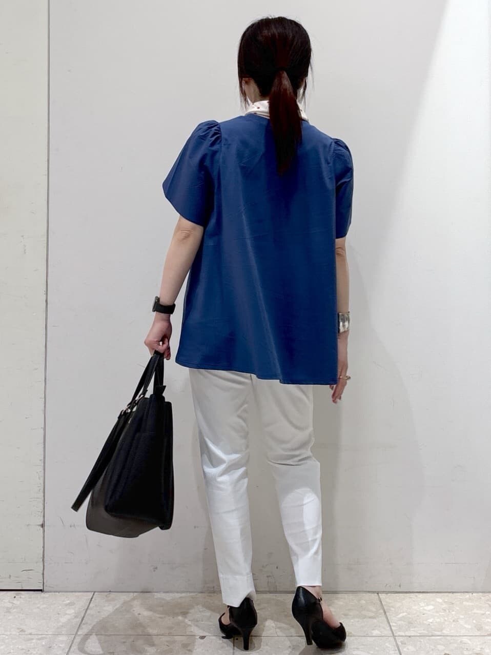 ブルー系のTシャツ/カットソー、ホワイト系のその他パンツ、ブラック系のトートバッグを着用したレディースの春コーディネートの3枚目の写真