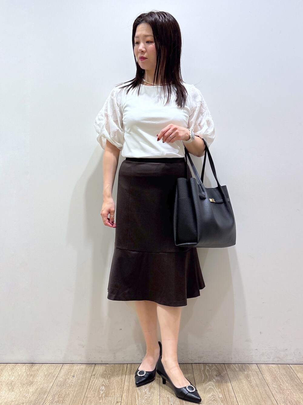 ホワイト系のTシャツ/カットソー、ブラウン系のスカート、ブラック系のトートバッグを着用したレディースの夏コーディネートの9枚目の写真