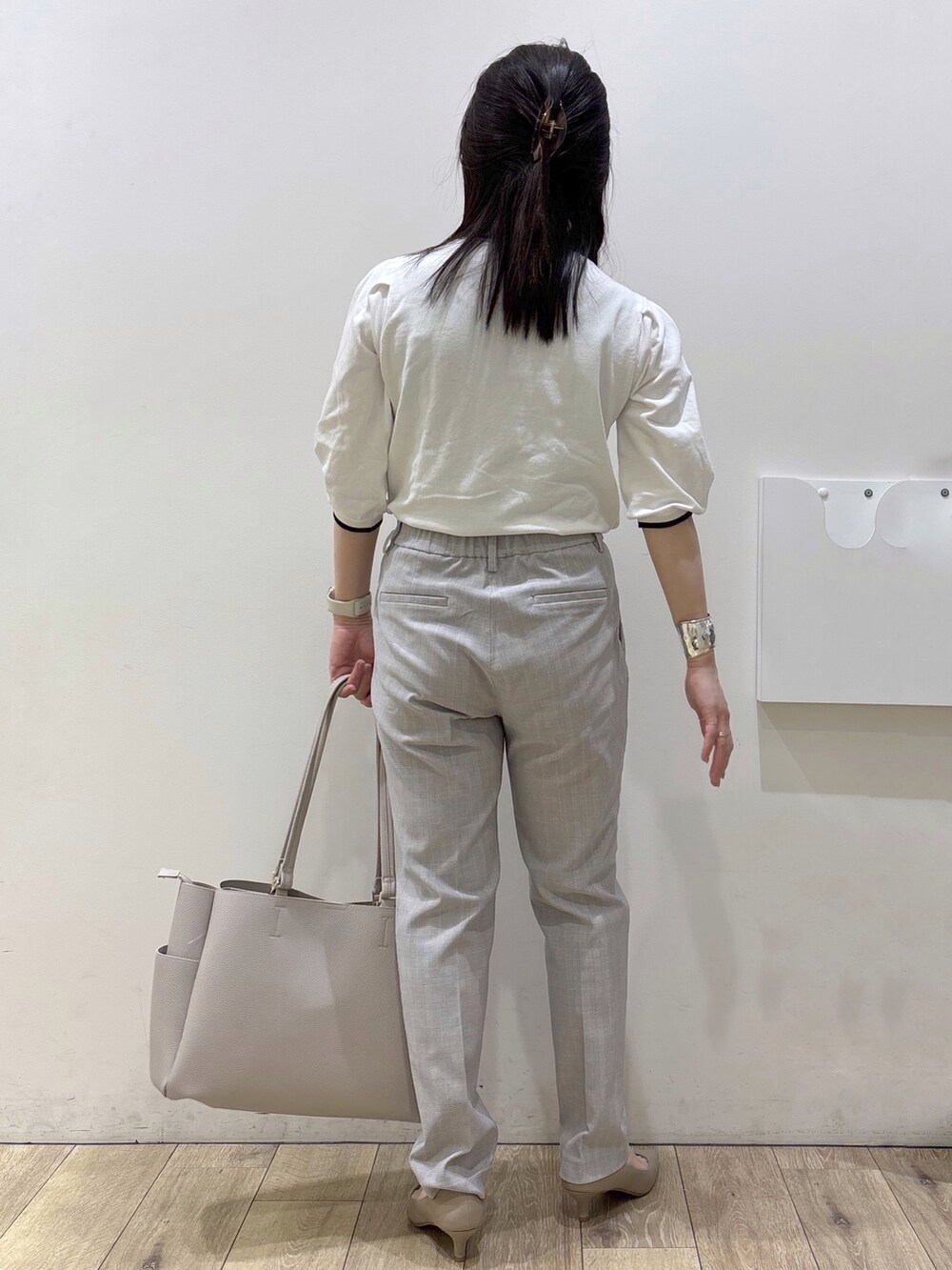 ベージュ系のパンプス、グレー系のカーディガン/ボレロ、ベージュ系のトートバッグを着用したレディースの春コーディネートの3枚目の写真