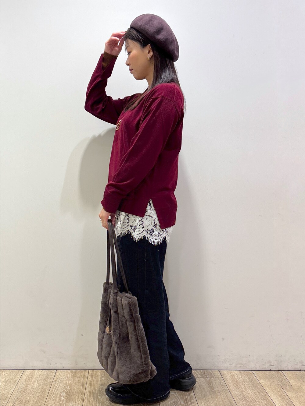 ブラウン系のノーカラーコート、レッド系のニット/セーター、ホワイト系のTシャツ/カットソーを着用したレディースの秋コーディネートの6枚目の写真