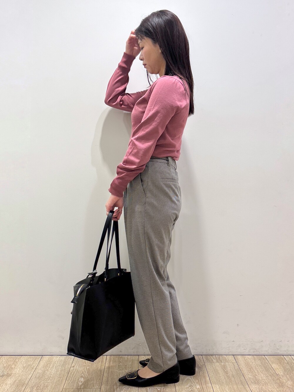 ピンク系のニット/セーター、ブラック系のその他パンツ、ブラック系のトートバッグを着用したレディースの秋コーディネートの4枚目の写真