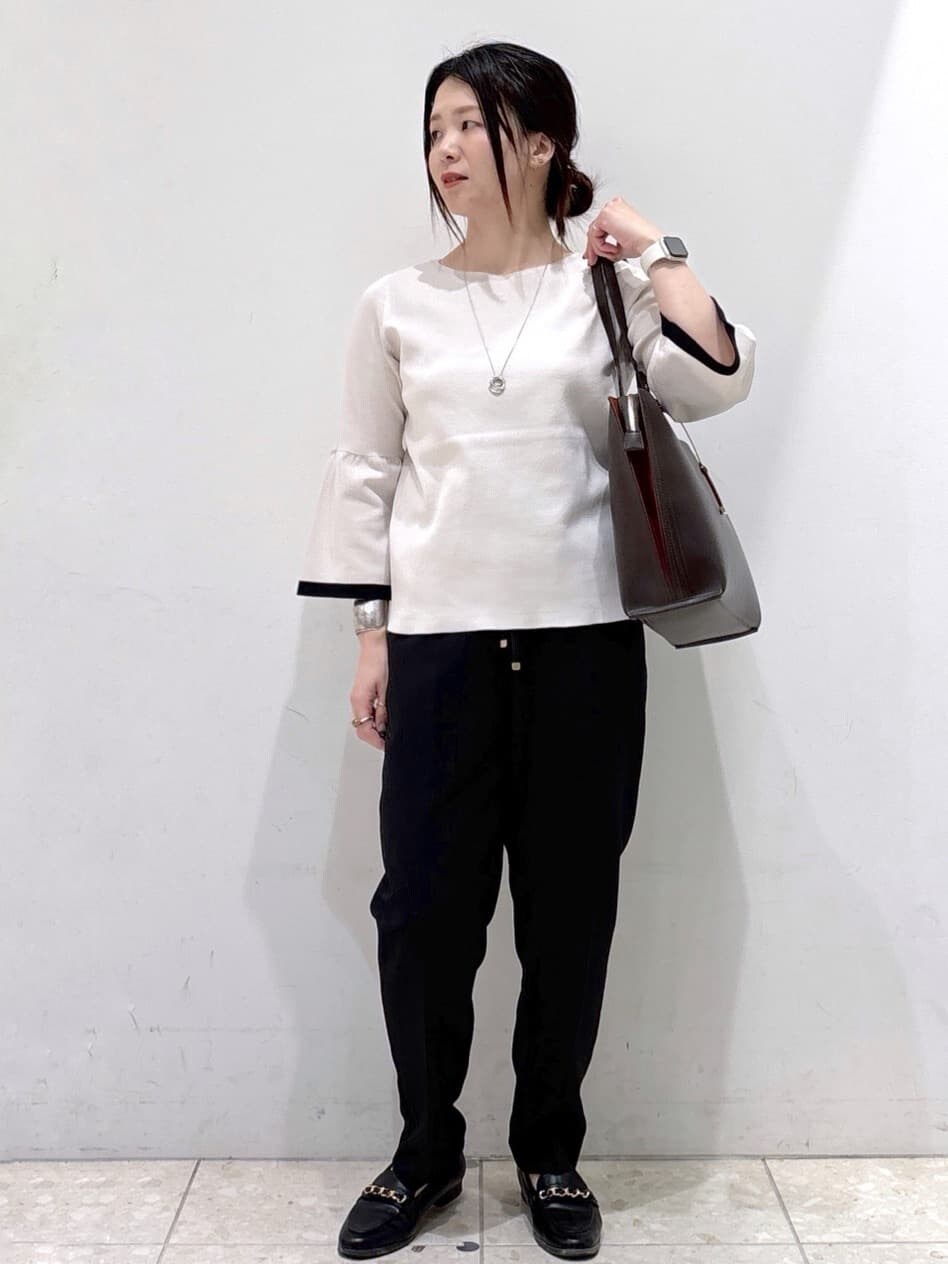 グレー系のニット/セーター、ブラック系のその他パンツ、ブラウン系のトートバッグを着用したレディースの秋コーディネートの6枚目の写真
