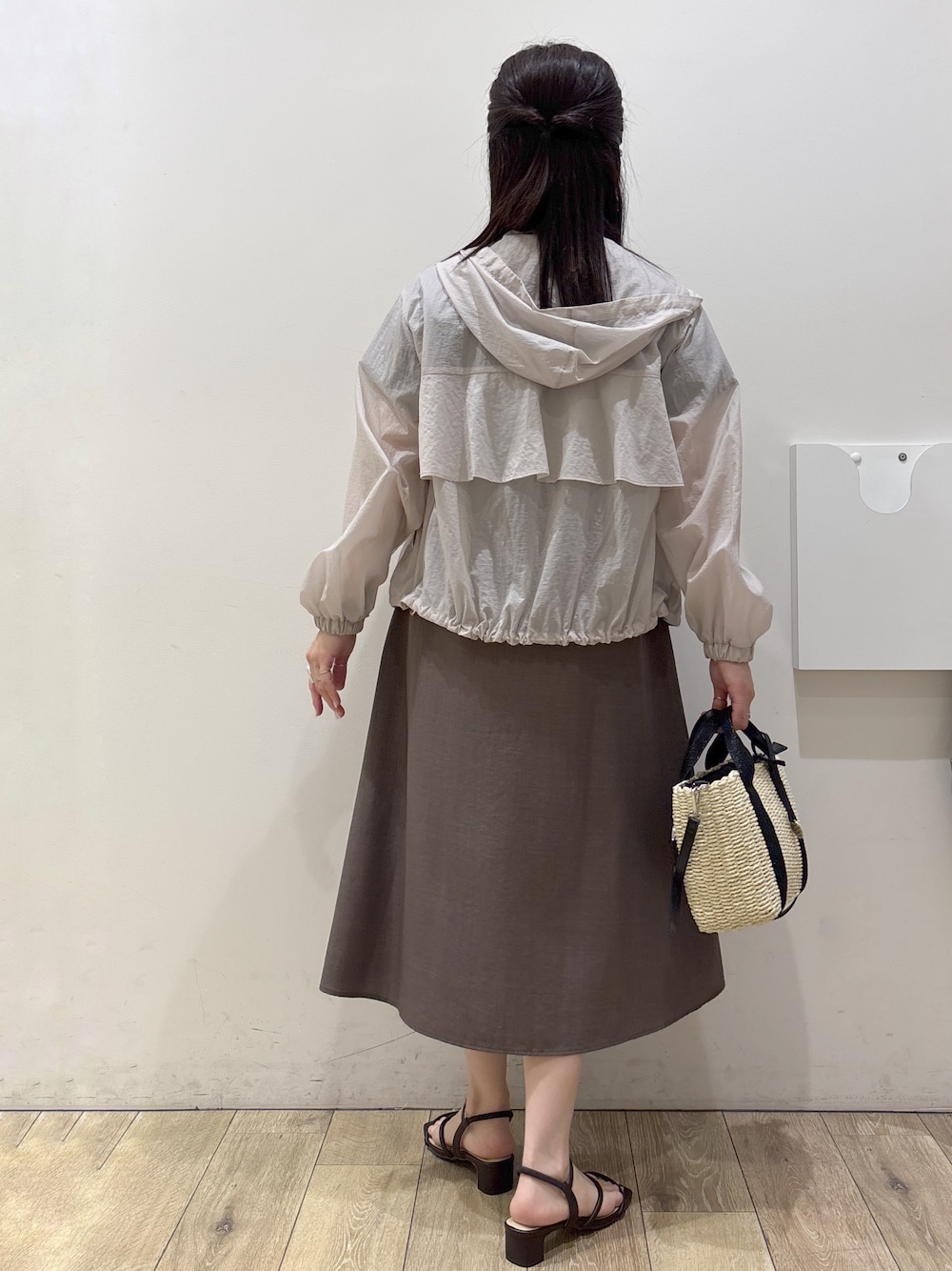 ブラック系のトートバッグ、ブラウン系のサンダル、ベージュ系のブルゾンを着用したレディースの春コーディネートの3枚目の写真