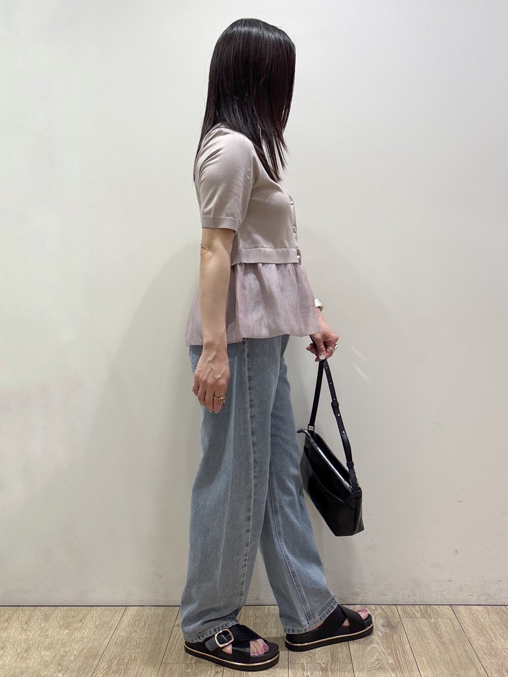ベージュ系のカーディガン/ボレロ、ブルー系のデニムパンツ、ブラック系のショルダーバッグを着用したレディースの夏コーディネートの2枚目の写真