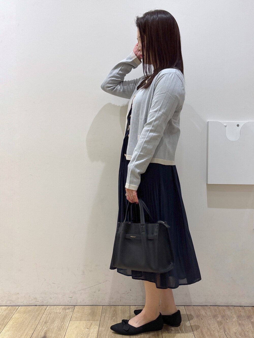 ブルー系のカーディガン/ボレロ、ブルー系のワンピース、ブラック系のトートバッグを着用したレディースの秋コーディネートの4枚目の写真