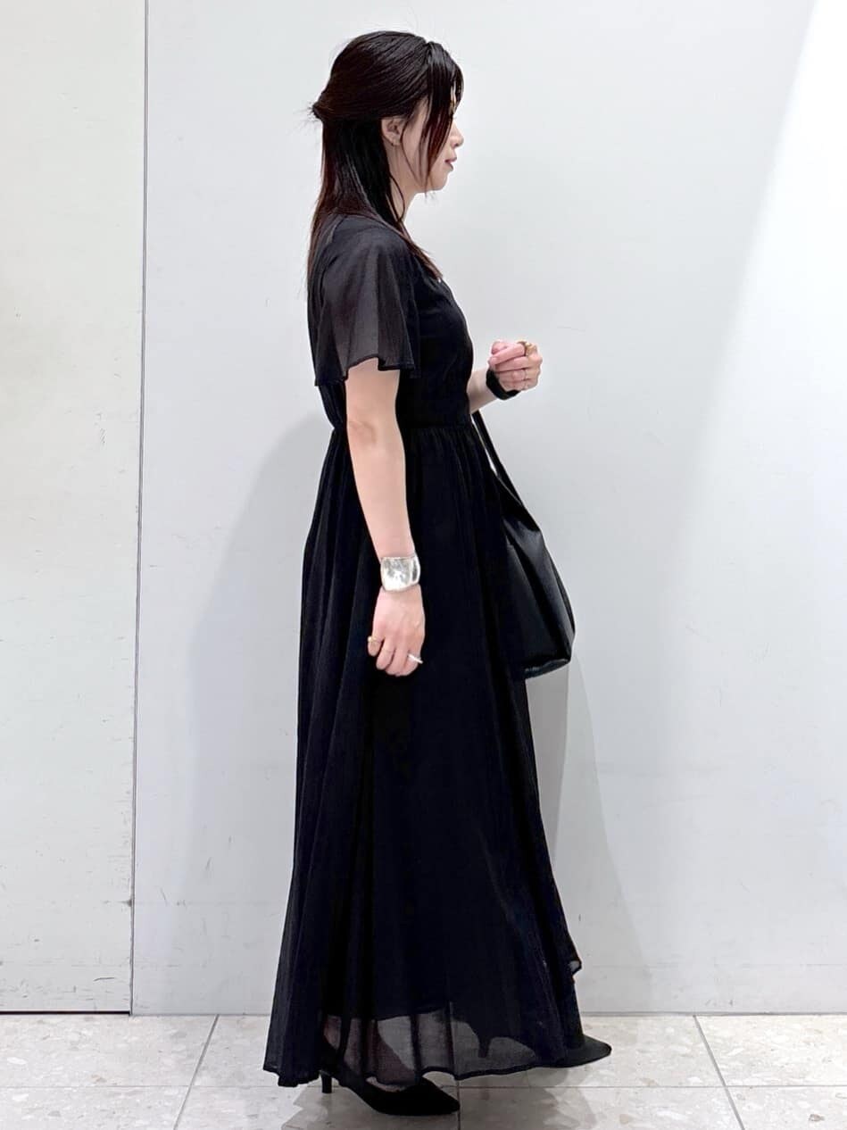 ブラック系のワンピース、ブラック系のトートバッグ、ブラック系のパンプスを着用したレディースの夏コーディネートの2枚目の写真