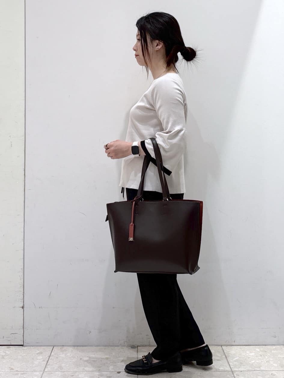 グレー系のニット/セーター、ブラック系のその他パンツ、ブラウン系のトートバッグを着用したレディースの秋コーディネートの4枚目の写真