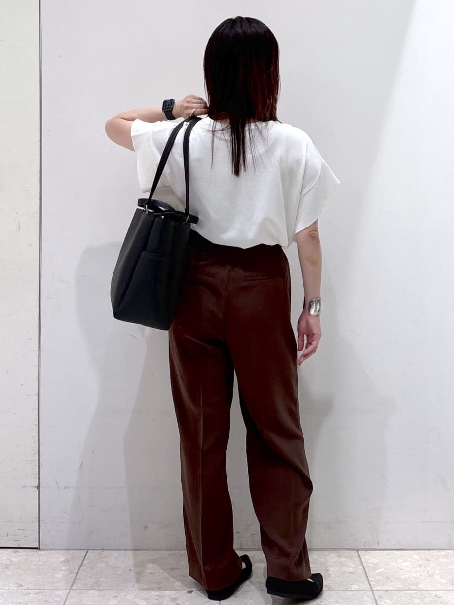 ホワイト系のニット/セーター、ブラウン系のその他パンツ、ブラック系のトートバッグを着用したレディースの夏コーディネートの3枚目の写真
