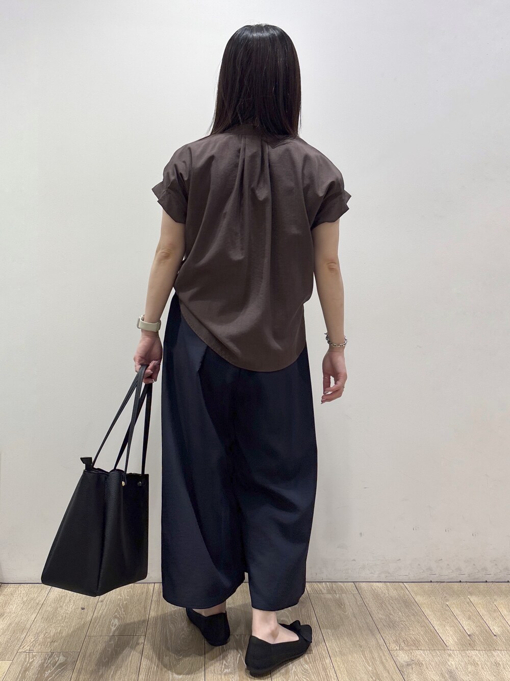ブラウン系のシャツ/ブラウス、ブルー系のその他パンツ、ブラック系のトートバッグを着用したレディースの夏コーディネートの3枚目の写真