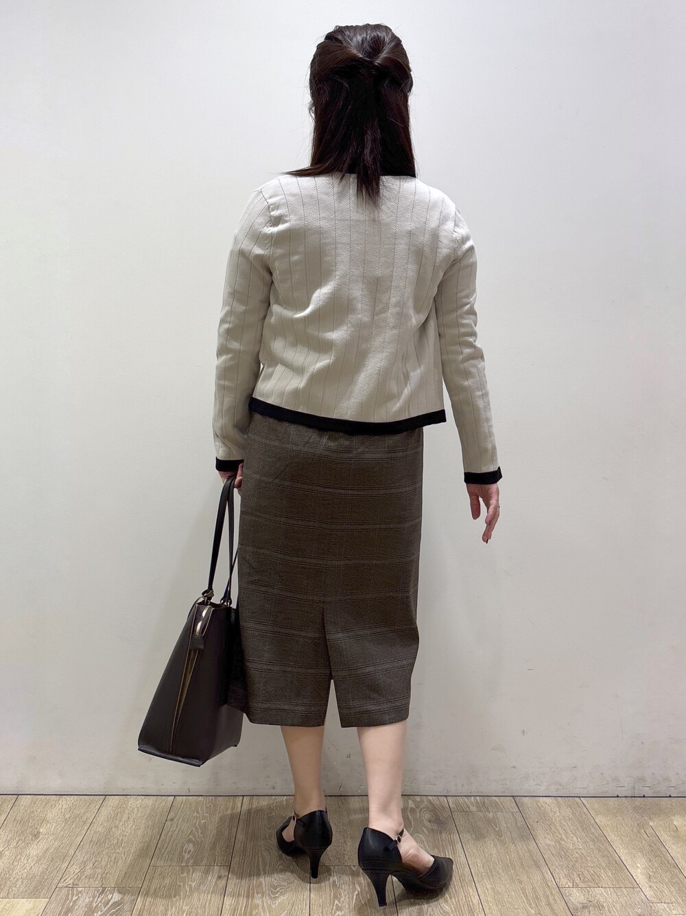 ベージュ系のカーディガン/ボレロ、レッド系のシャツ/ブラウス、ブラウン系のスカートを着用したレディースの秋コーディネートの3枚目の写真