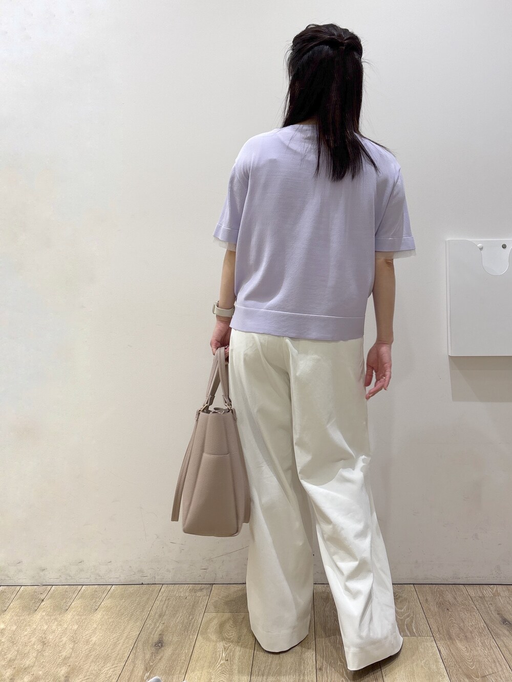 パープル系のニット/セーター、ホワイト系のその他パンツ、ベージュ系のトートバッグを着用したレディースの春コーディネートの3枚目の写真