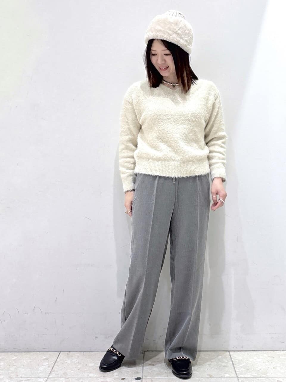 ホワイト系のダウンジャケット/コート、ベージュ系のニット/セーター、グレー系のその他パンツを着用したレディースの冬コーディネートの8枚目の写真