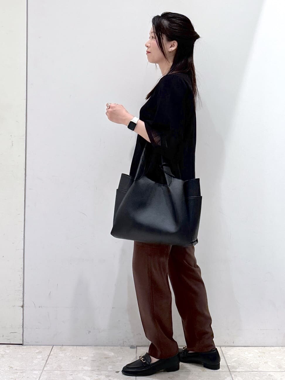 ブラック系のニット/セーター、ブラウン系のその他パンツ、ブラック系のトートバッグを着用したレディースの夏コーディネートの9枚目の写真