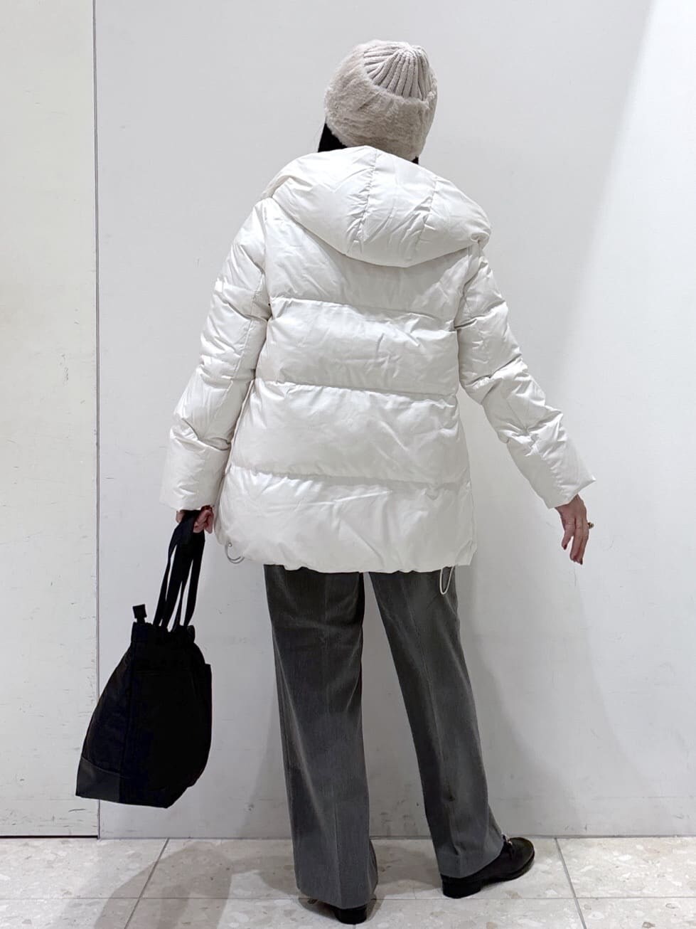 ホワイト系のダウンジャケット/コート、ベージュ系のニット/セーター、グレー系のその他パンツを着用したレディースの冬コーディネートの6枚目の写真