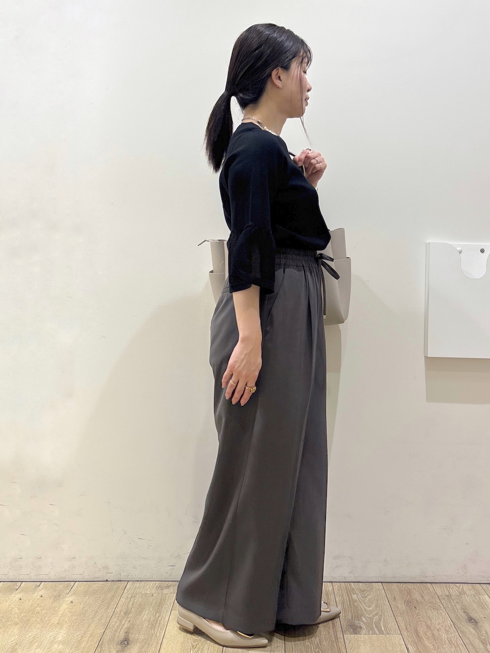 ベージュ系のパンプス、グレー系のカーディガン/ボレロ、ベージュ系のトートバッグを着用したレディースの春コーディネートの2枚目の写真