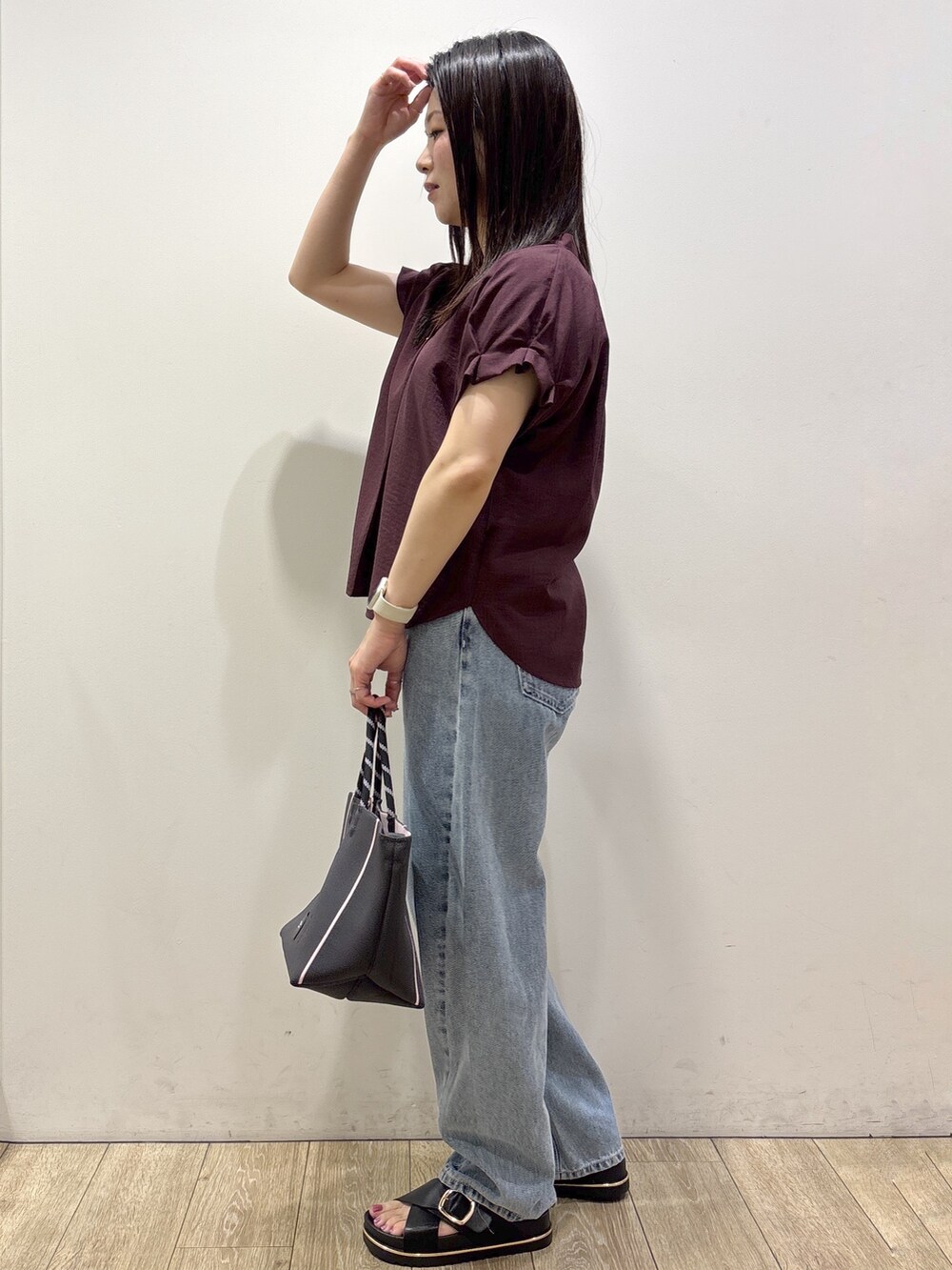レッド系のシャツ/ブラウス、ブルー系のデニムパンツ、グレー系のトートバッグを着用したレディースの夏コーディネートの4枚目の写真