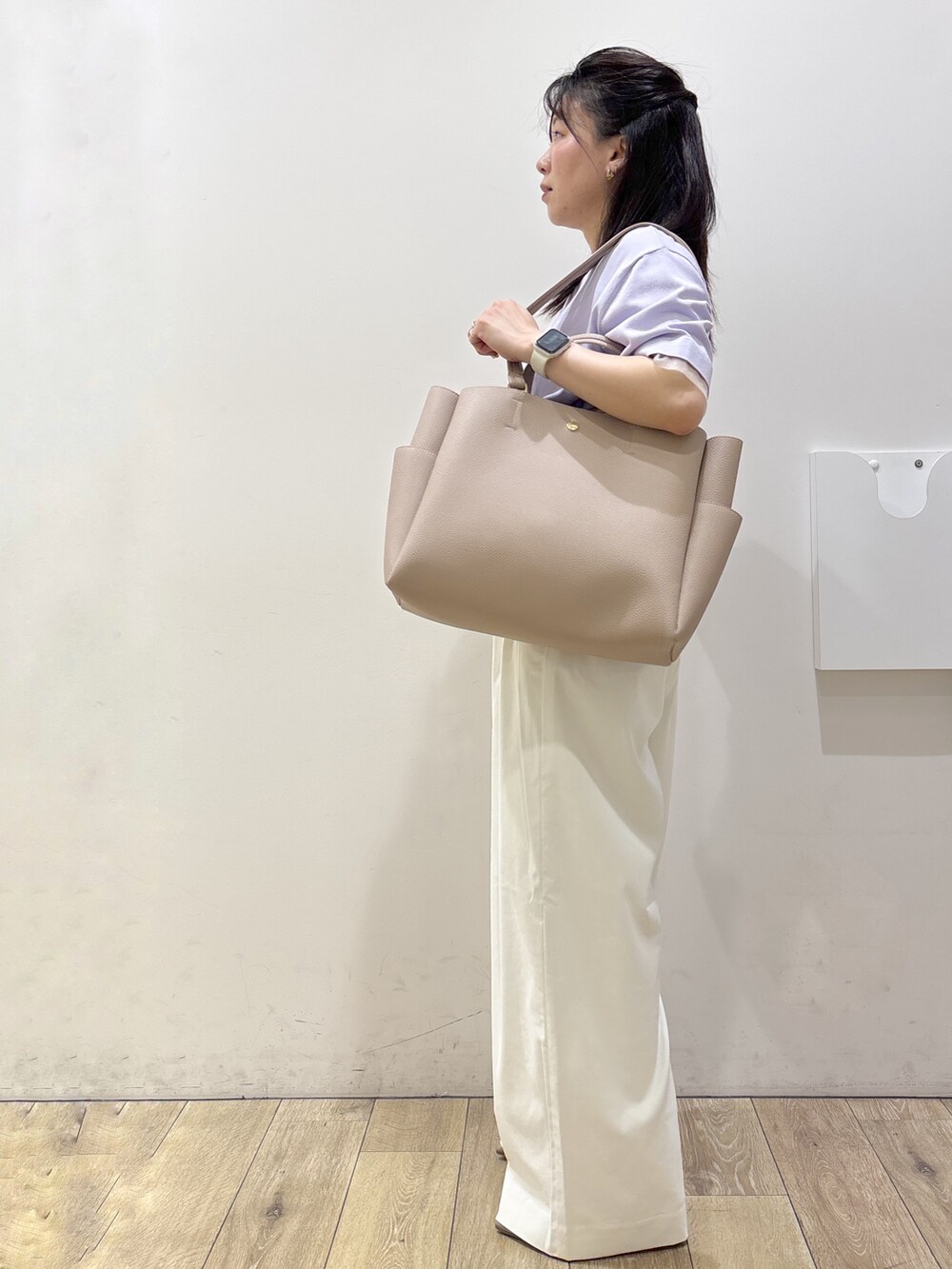 パープル系のニット/セーター、ホワイト系のその他パンツ、ベージュ系のトートバッグを着用したレディースの春コーディネートの6枚目の写真