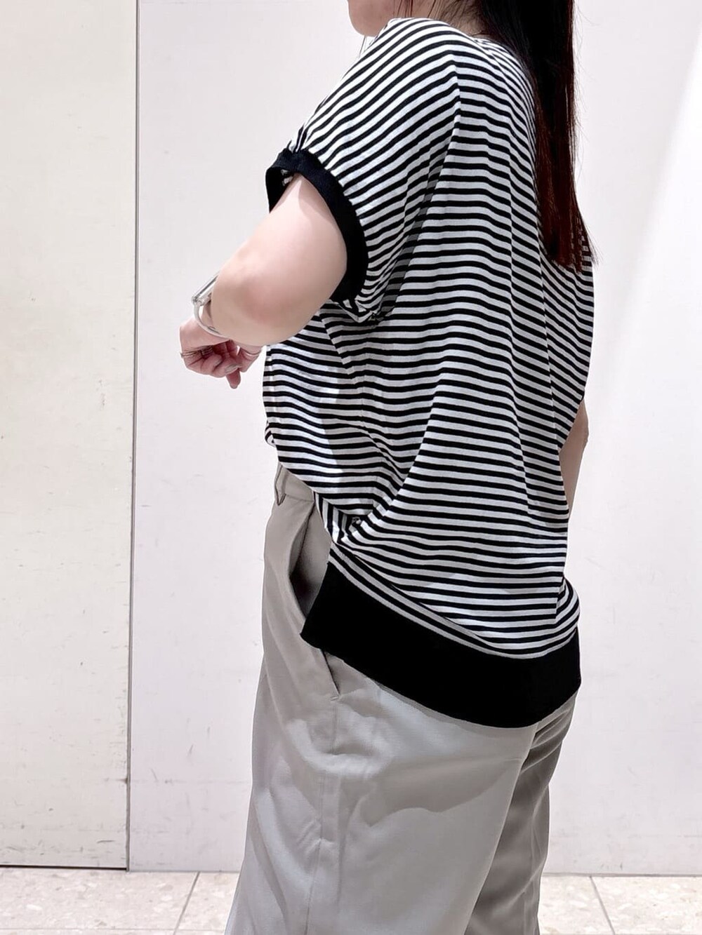 ブラック系のニット/セーター、ブラウン系のその他パンツ、ブラック系のトートバッグを着用したレディースの夏コーディネートの8枚目の写真