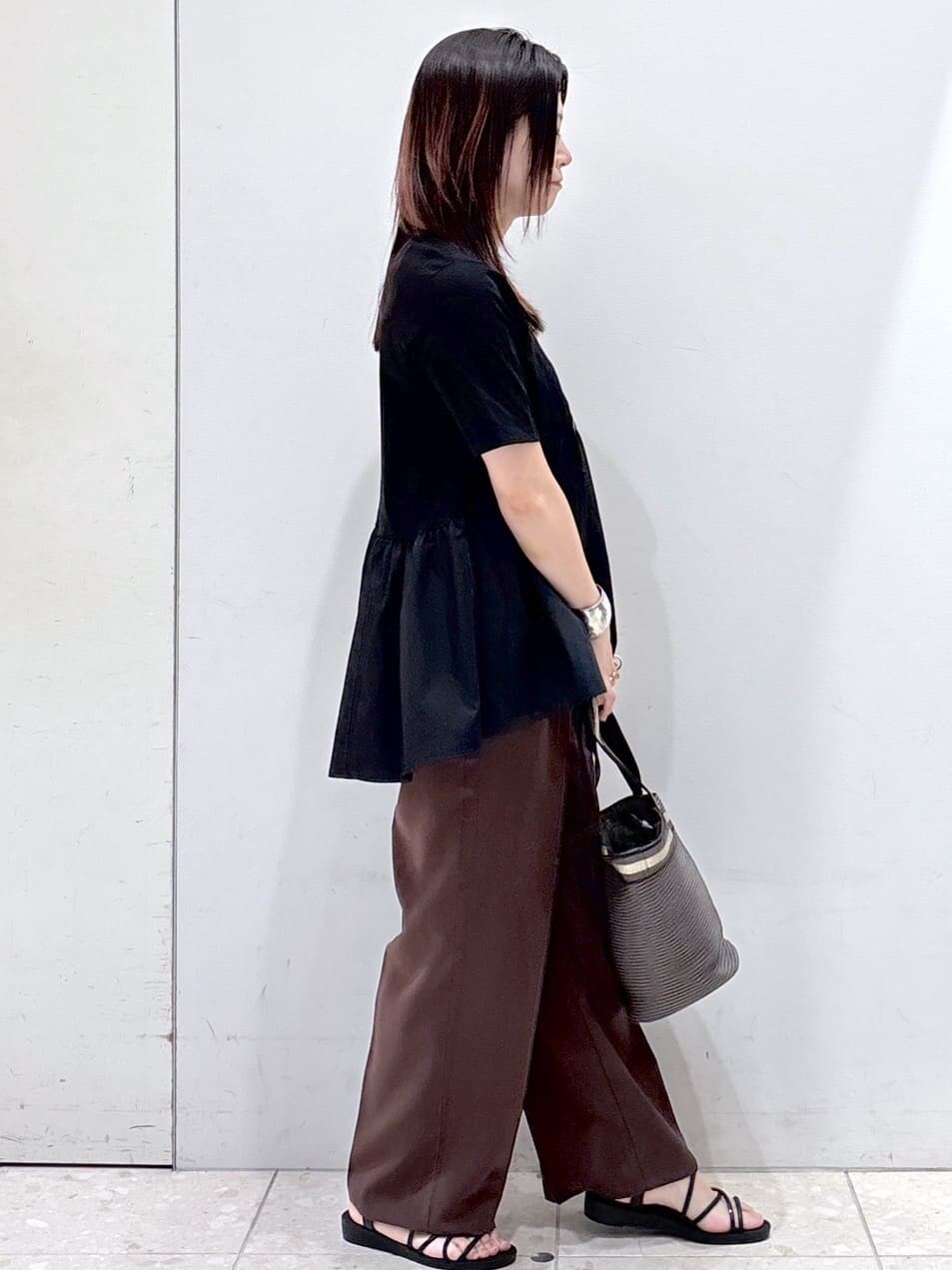 ブラック系のTシャツ/カットソー、ブラウン系のその他パンツ、ブラウン系のトートバッグを着用したレディースの夏コーディネートの2枚目の写真