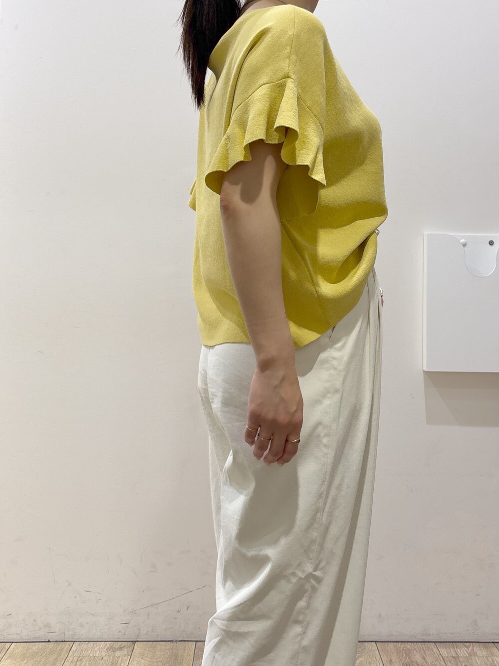 イエロー系のニット/セーター、ホワイト系のその他パンツ、ブラウン系のトートバッグを着用したレディースの春コーディネートの7枚目の写真