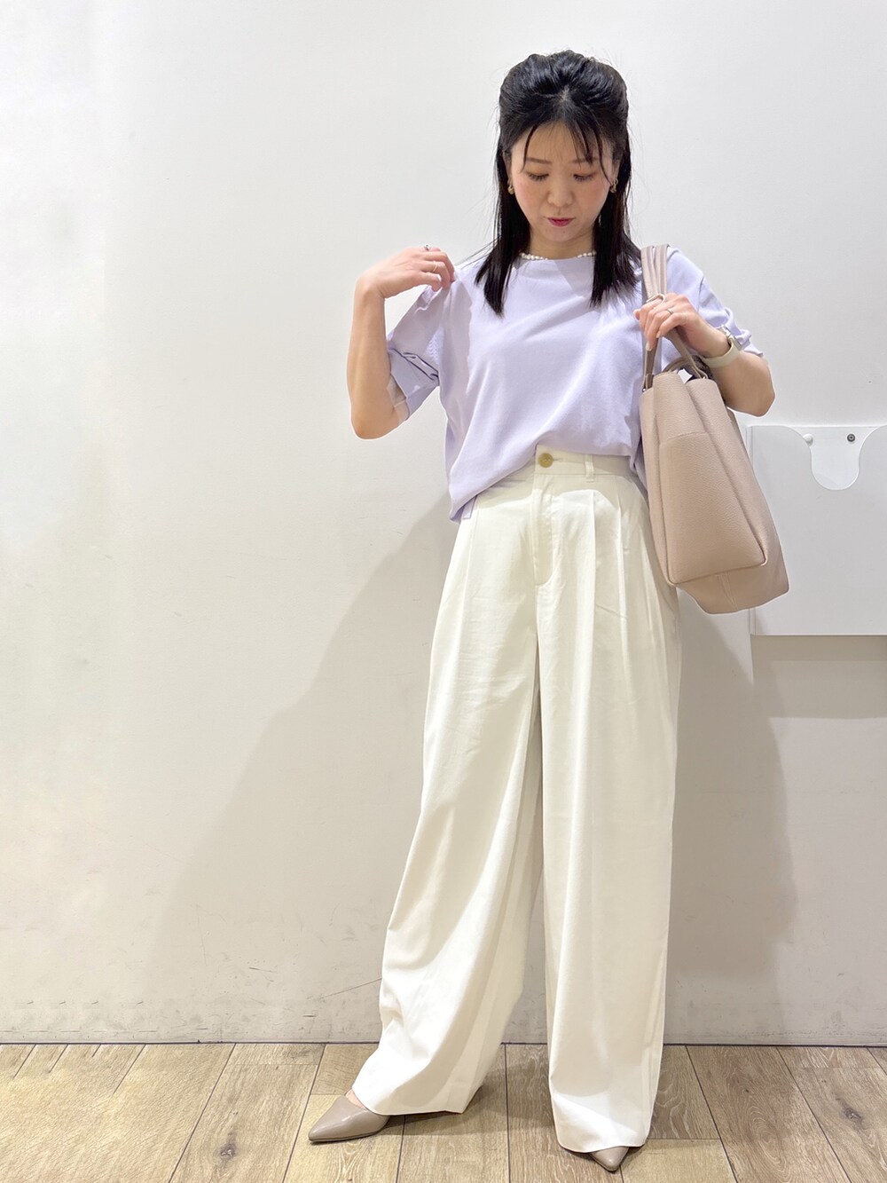 パープル系のニット/セーター、ホワイト系のその他パンツ、ベージュ系のトートバッグを着用したレディースの春コーディネートの5枚目の写真