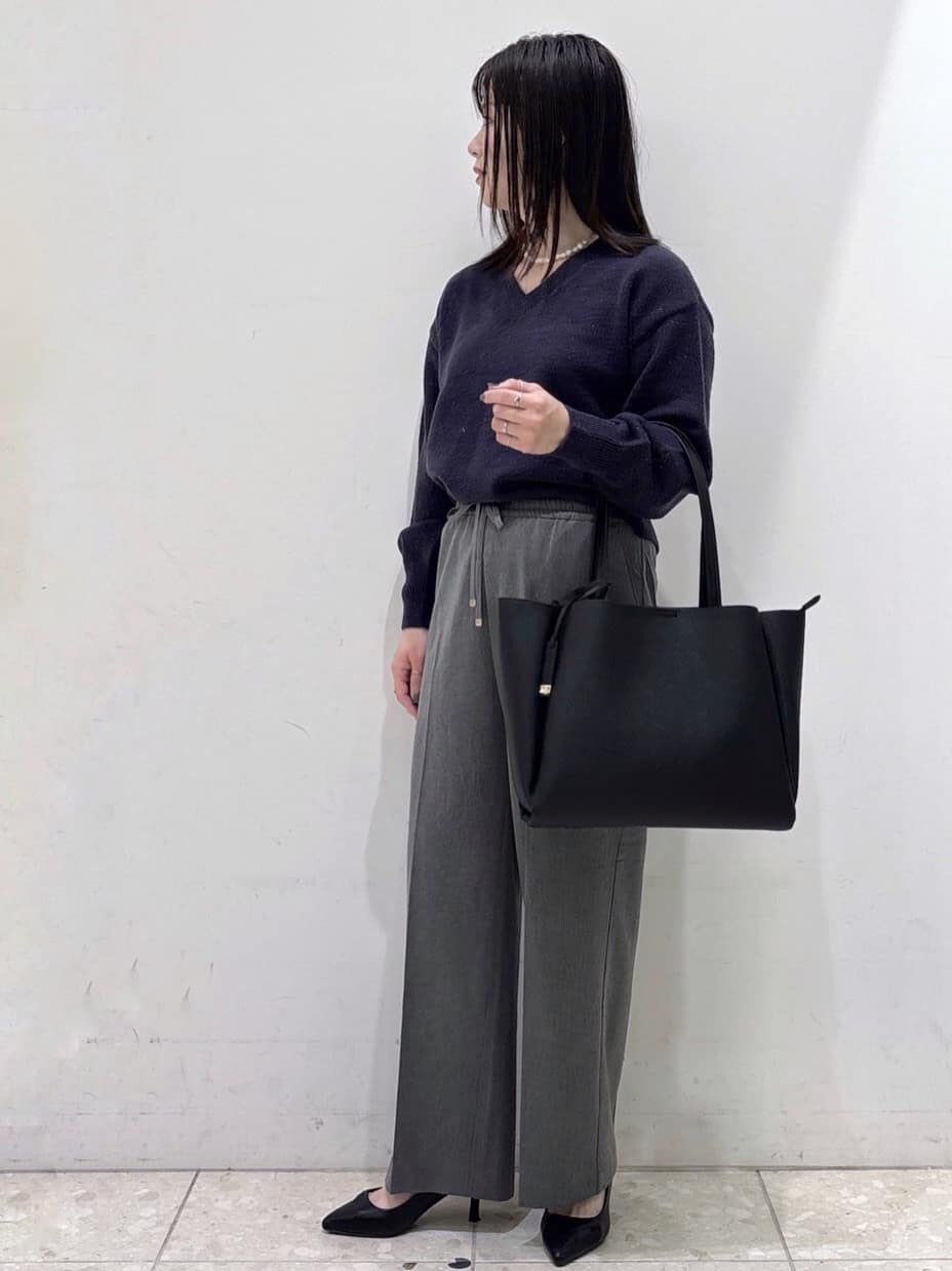 ブラック系のステンカラーコート、ブルー系のニット/セーター、グレー系のその他パンツを着用したレディースの冬コーディネートの7枚目の写真