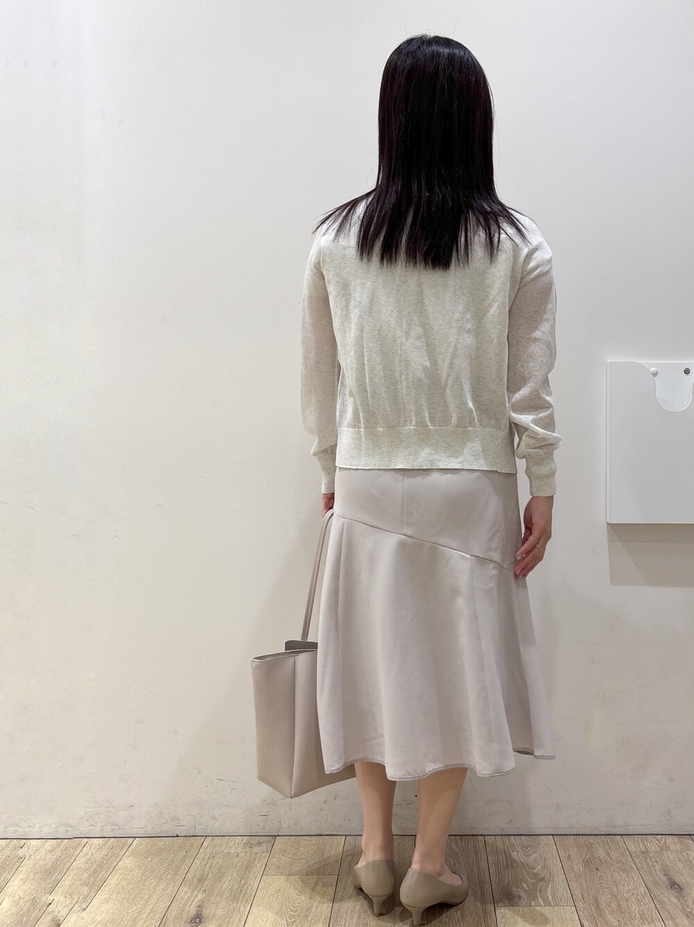 ホワイト系のカーディガン/ボレロ、ホワイト系のシャツ/ブラウス、ベージュ系のスカートを着用したレディースの夏コーディネートの4枚目の写真