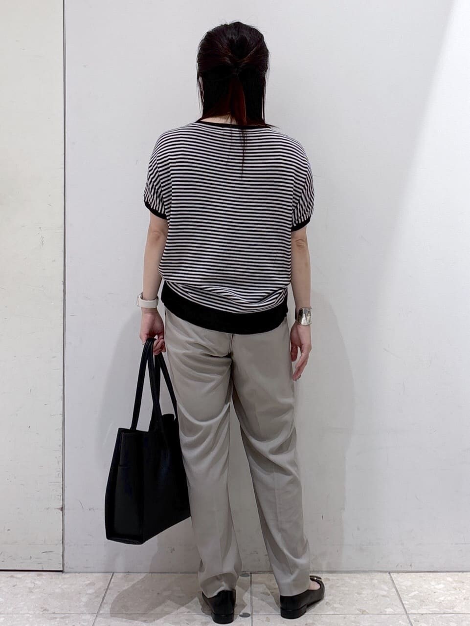 ブラック系のニット/セーター、ブラウン系のその他パンツ、ブラック系のトートバッグを着用したレディースの夏コーディネートの3枚目の写真