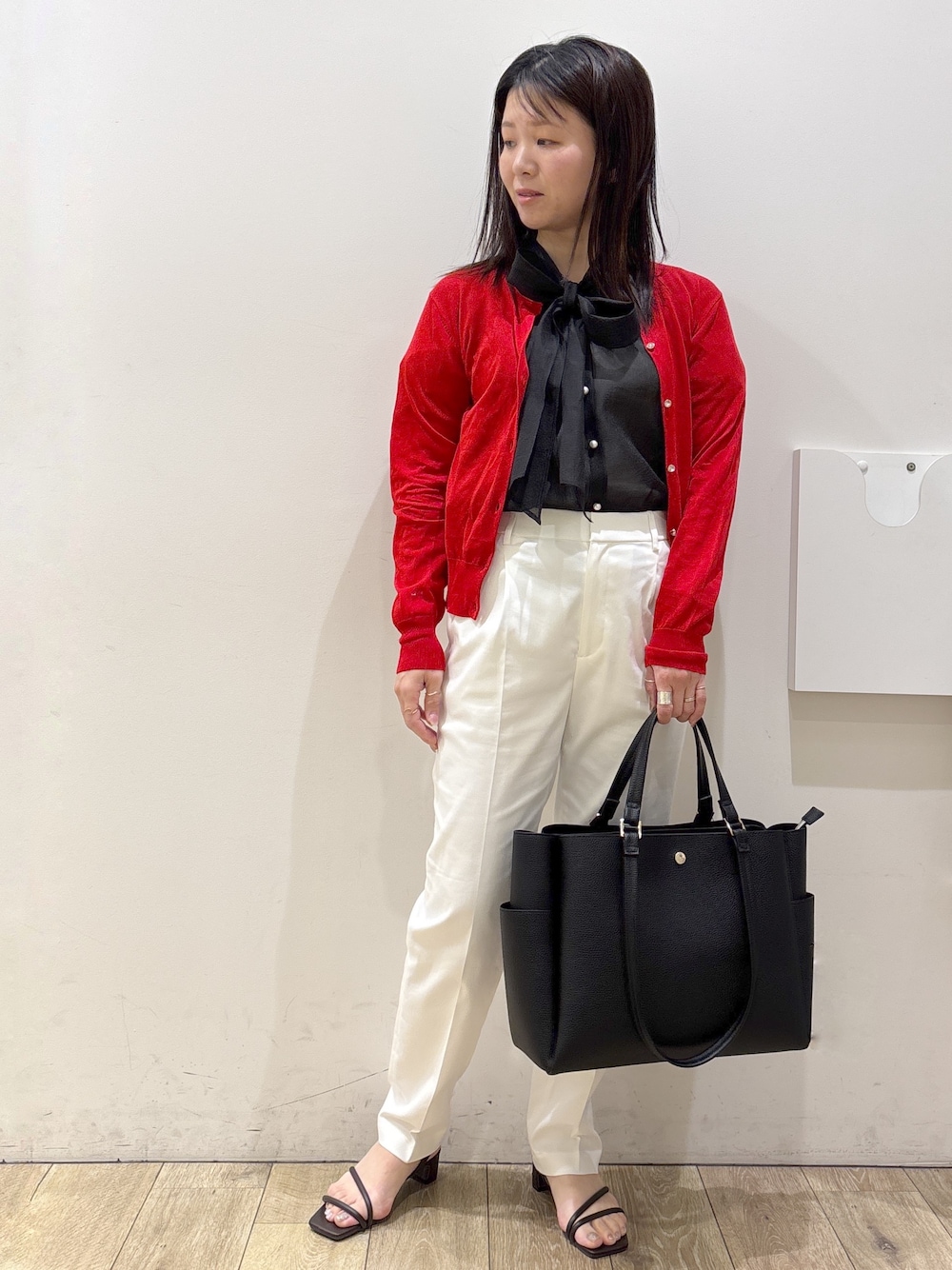 ブラック系のトートバッグ、ブラウン系のサンダル、ホワイト系のその他パンツを着用したレディースの春コーディネートの5枚目の写真