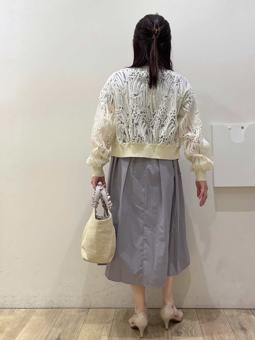 ホワイト系のカーディガン/ボレロ、グレー系のワンピース、ベージュ系のトートバッグを着用したレディースの春コーディネートの3枚目の写真