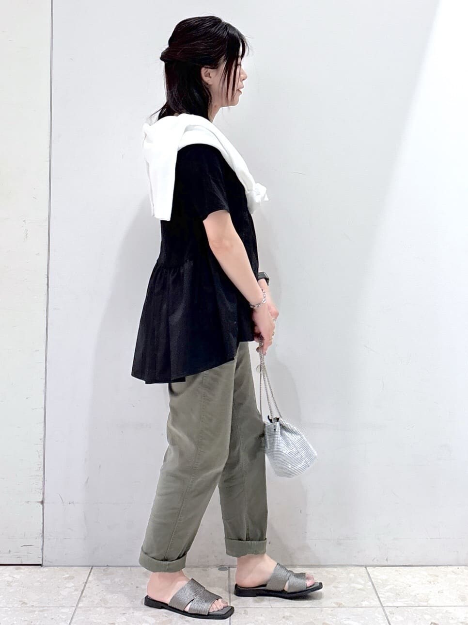 ブラック系のTシャツ/カットソー、ホワイト系のカーディガン/ボレロ、グリーン系のその他パンツを着用したレディースの春コーディネートの2枚目の写真