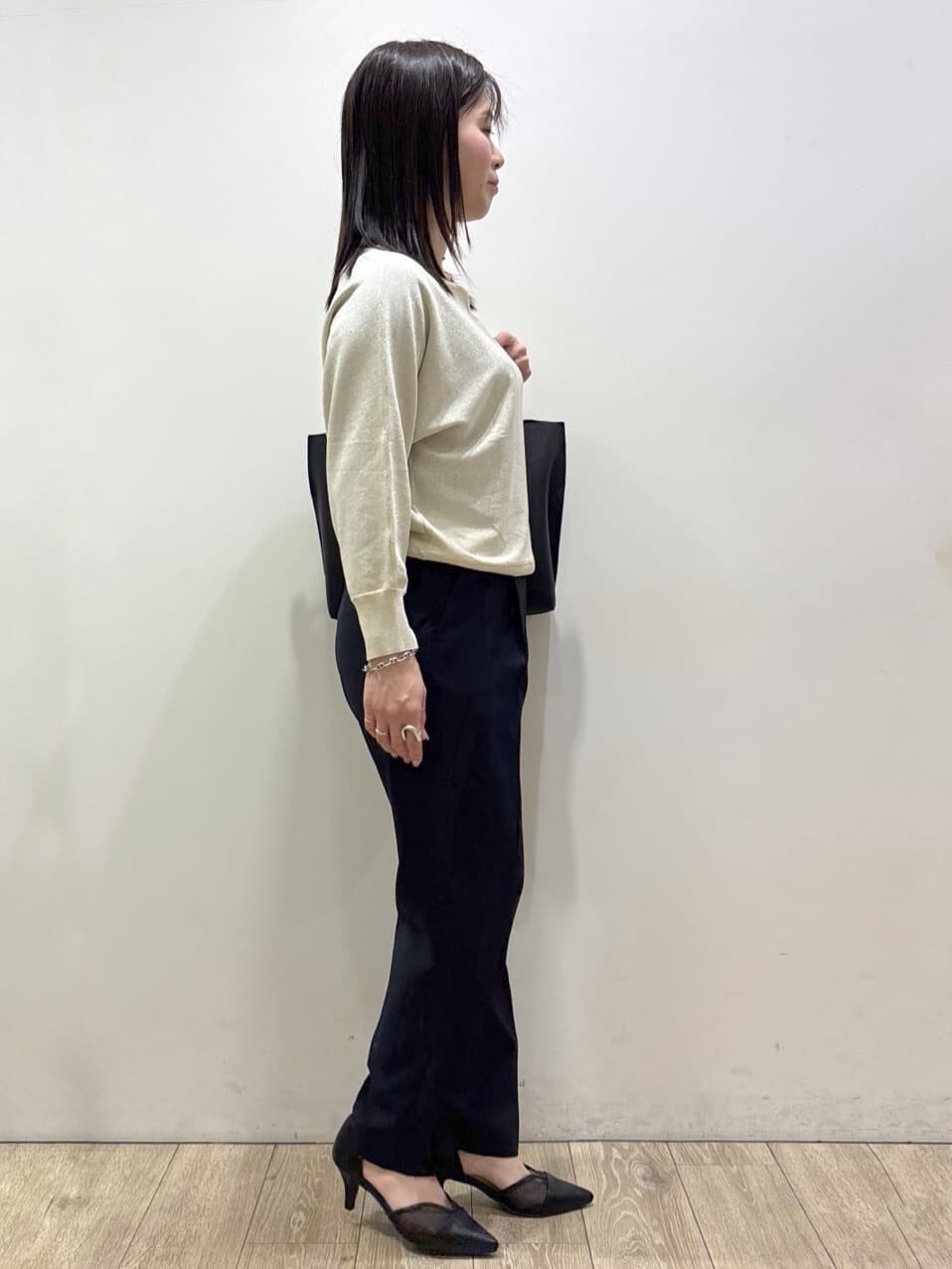 ホワイト系のニット/セーター、ブルー系のその他パンツ、ブラック系のトートバッグを着用したレディースの春コーディネートの4枚目の写真