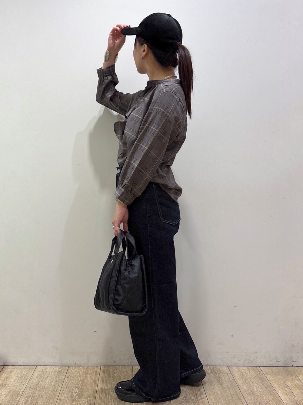 グレー系のシャツ/ブラウス、ブルー系のデニムパンツ、ブラック系のトートバッグを着用したレディースの秋コーディネートの4枚目の写真