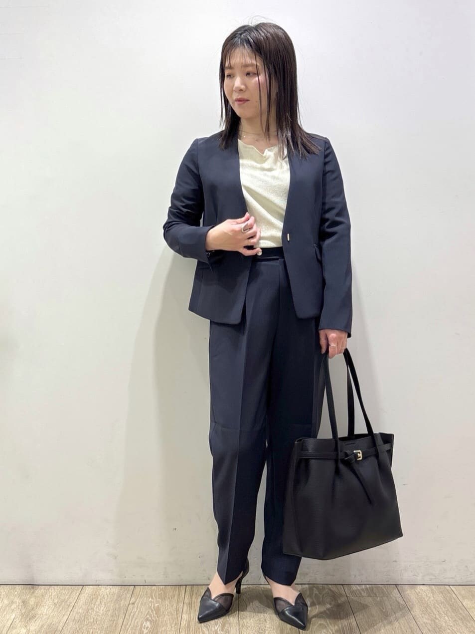 ブルー系のノーカラージャケット、ホワイト系のニット/セーター、ブルー系のその他パンツを着用したレディースの春コーディネートの6枚目の写真
