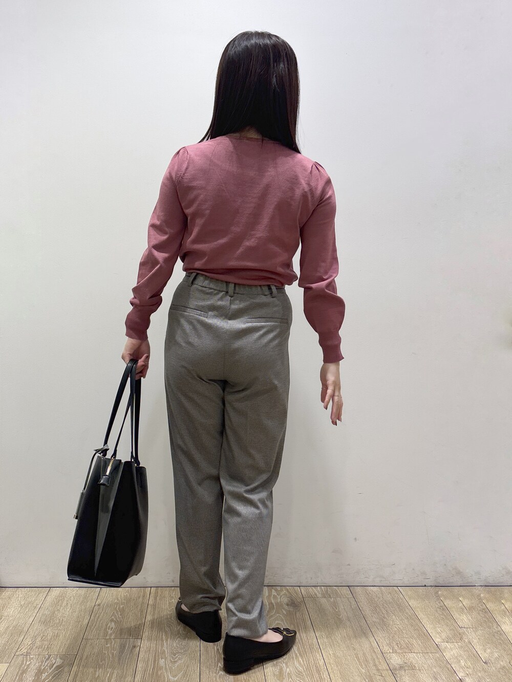 ピンク系のニット/セーター、ブラック系のその他パンツ、ブラック系のトートバッグを着用したレディースの秋コーディネートの3枚目の写真