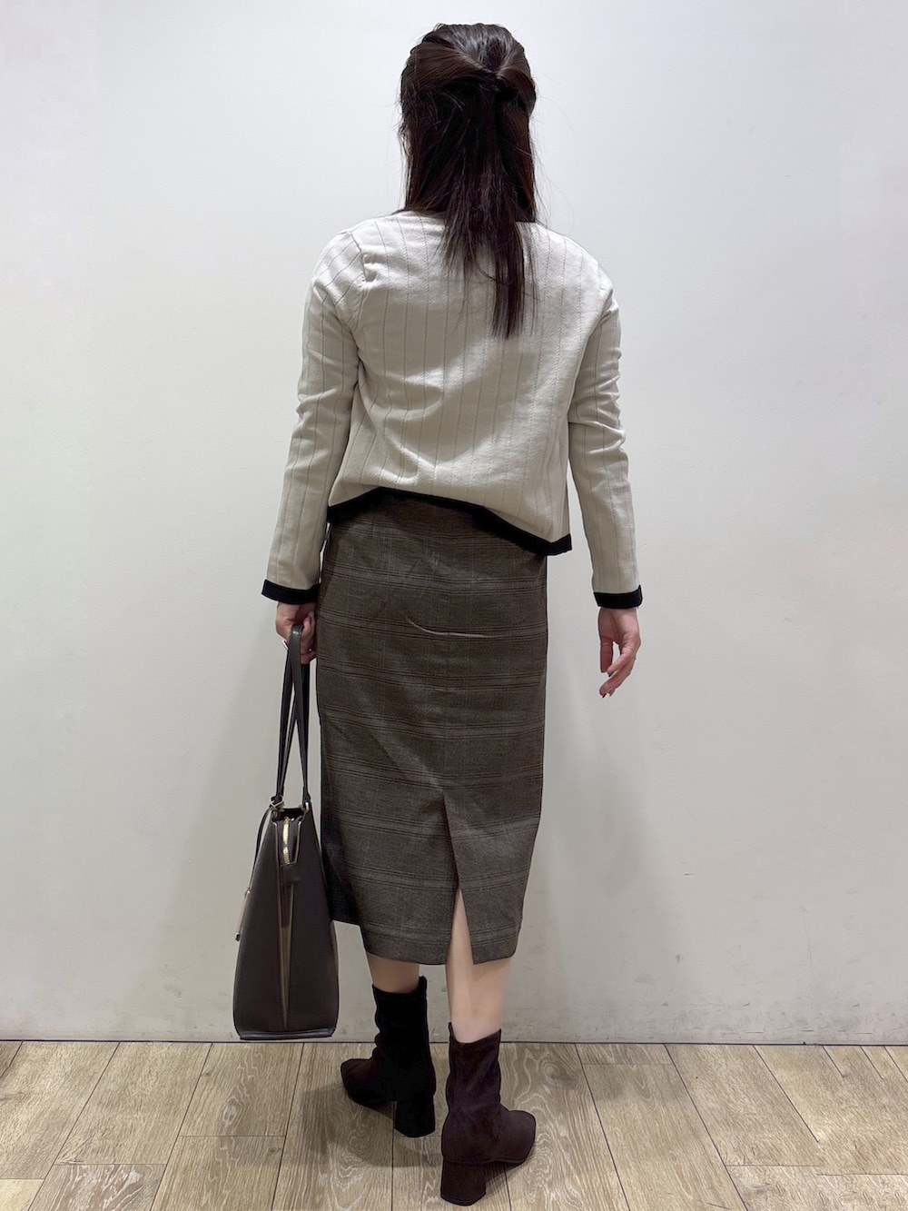 ベージュ系のカーディガン/ボレロ、レッド系のシャツ/ブラウス、ブラウン系のスカートを着用したレディースの秋コーディネートの3枚目の写真
