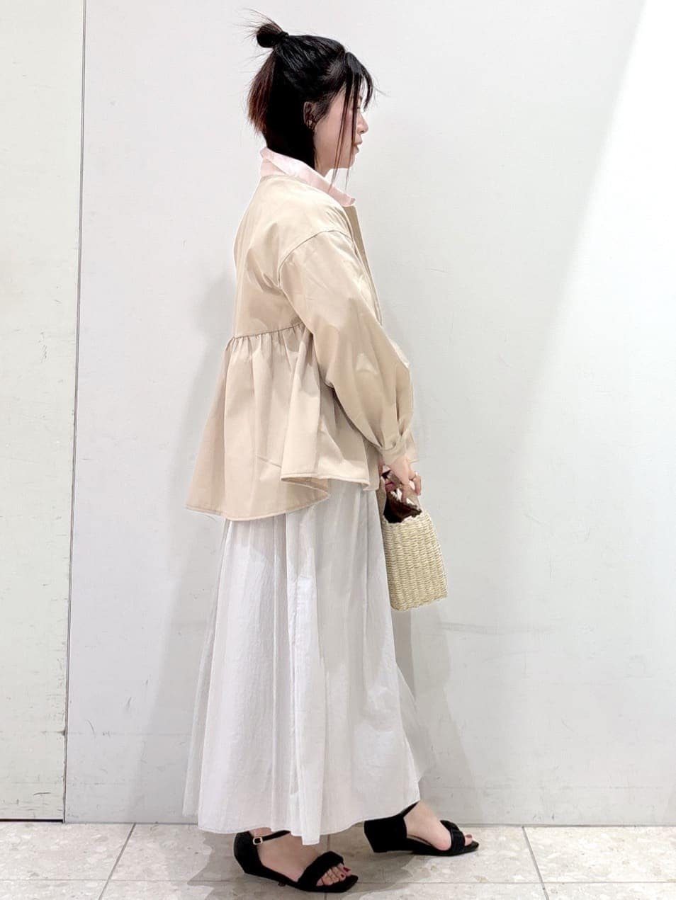 ベージュ系のノーカラージャケット、ピンク系のシャツ/ブラウス、グレー系のスカートを着用したレディースの春コーディネートの2枚目の写真